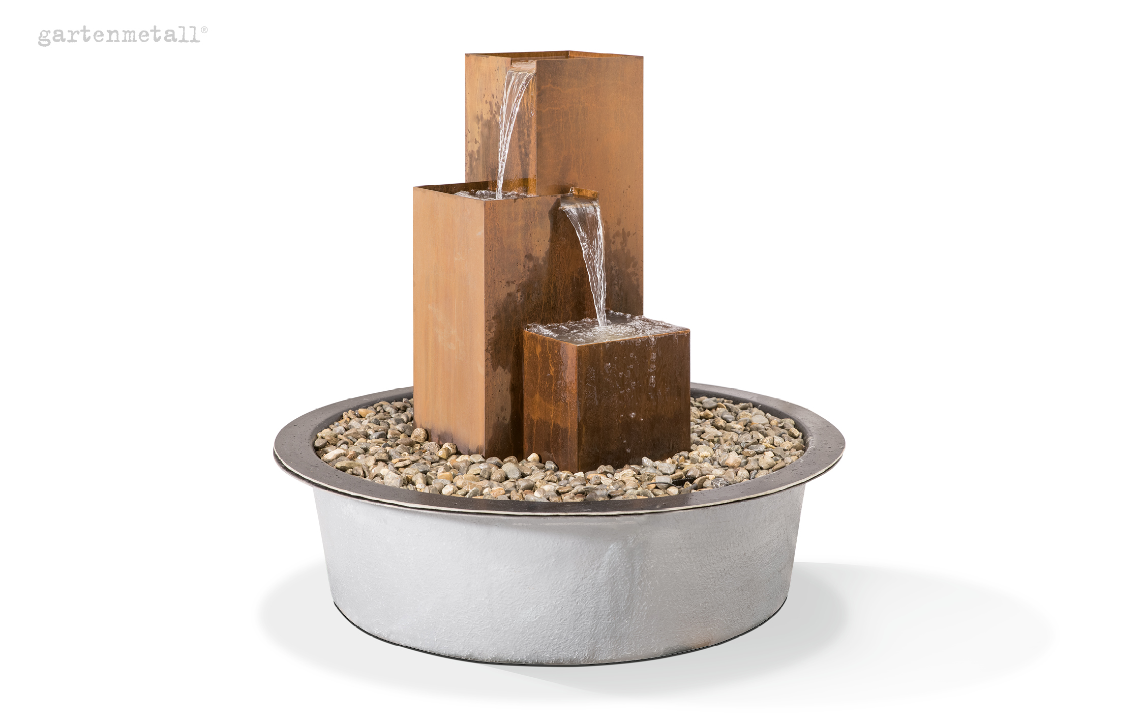 Ein Metallbrunnen mit drei gestaffelten, rechteckigen Blöcken gießt Wasser in einen runden, mit Steinen gefüllten Behälter. Links oben steht „gartenmetall®“.