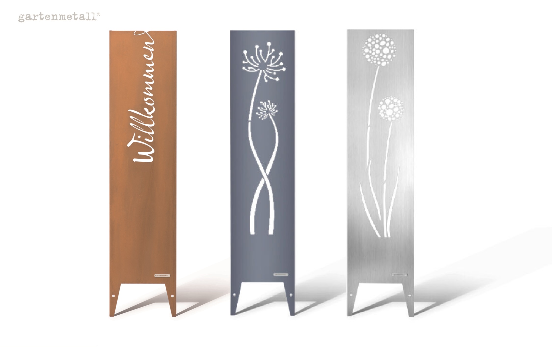 Drei Metallstelen stehen nebeneinander. Die erste ist rostfarben mit 'Willkommen' in Weiß, die zweite dunkelgrau mit Blumenmotiven, die dritte silbern mit Kreisen. Oben links: 'gartenmetall®'.