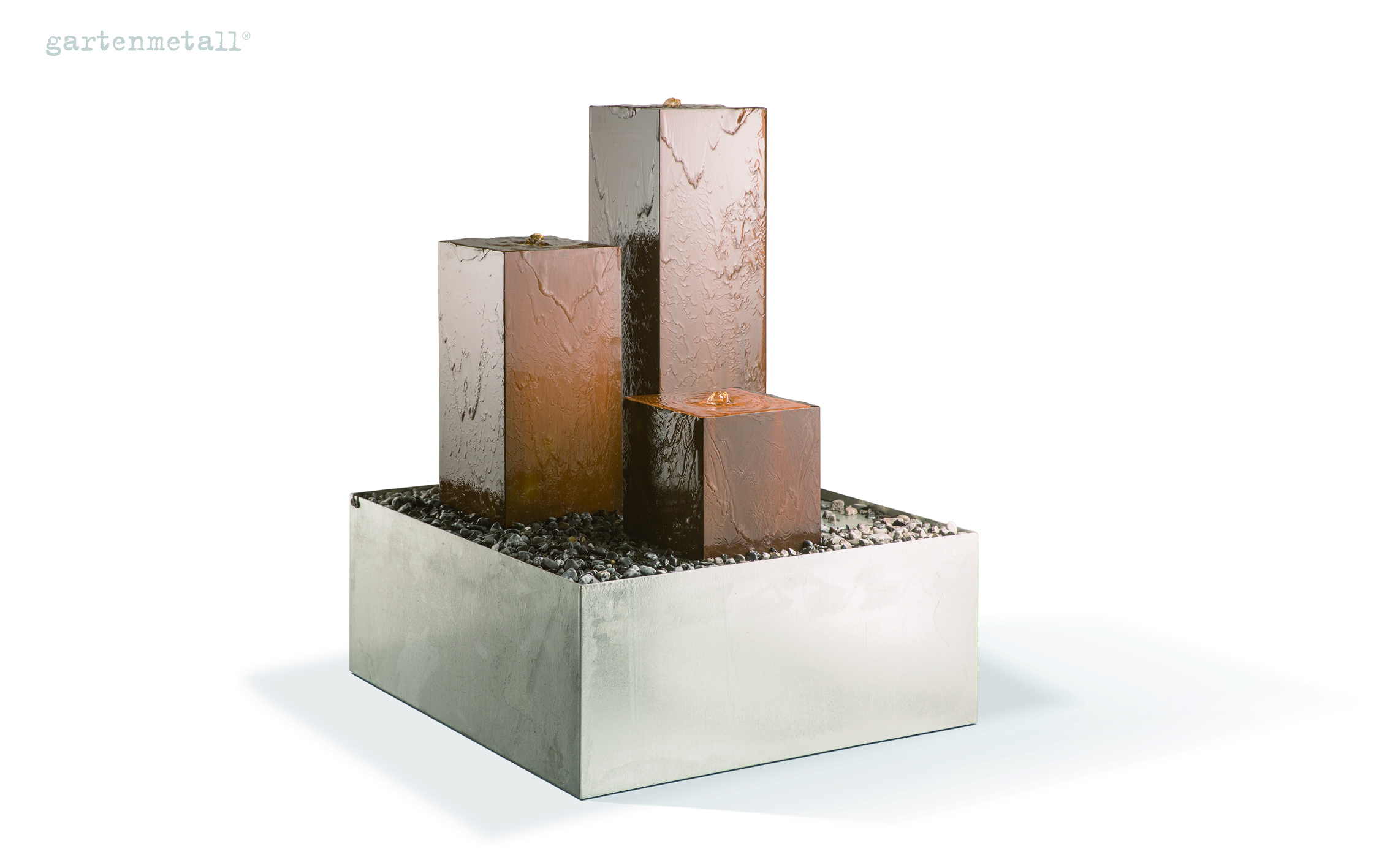 Drei rechteckige Wasserfontänen sprudeln auf Metallquadern, umgeben von kleinen Steinen in einem quadratischen Becken. Oben links steht in blauer Schrift 'gartenmetall®'.