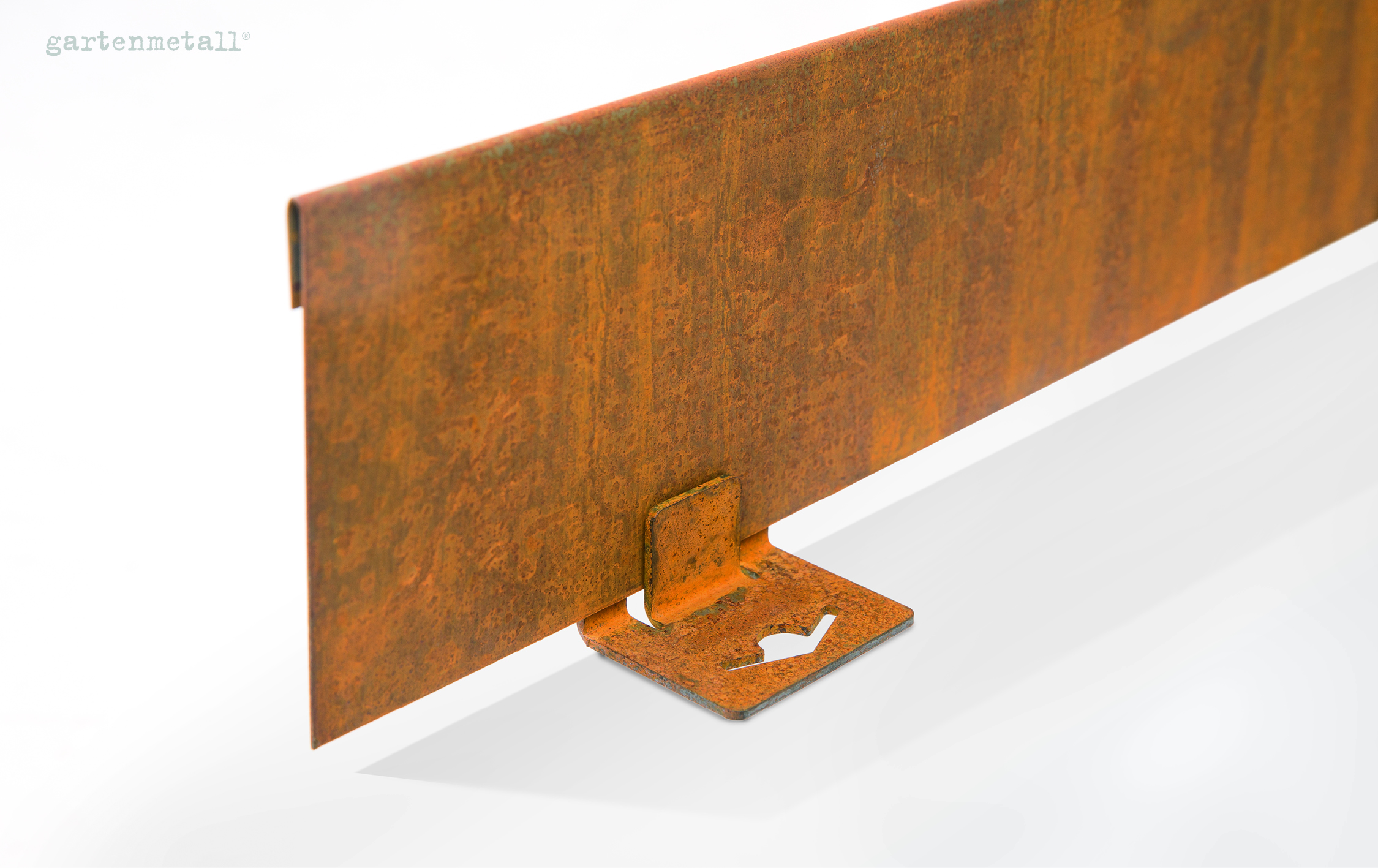 Rostfarbige Metallplatte steht auf einer quadratischen Basis mit ausgeschnittenem Herz, auf glänzendem weißen Hintergrund. Text: 'gartenmetall®'.