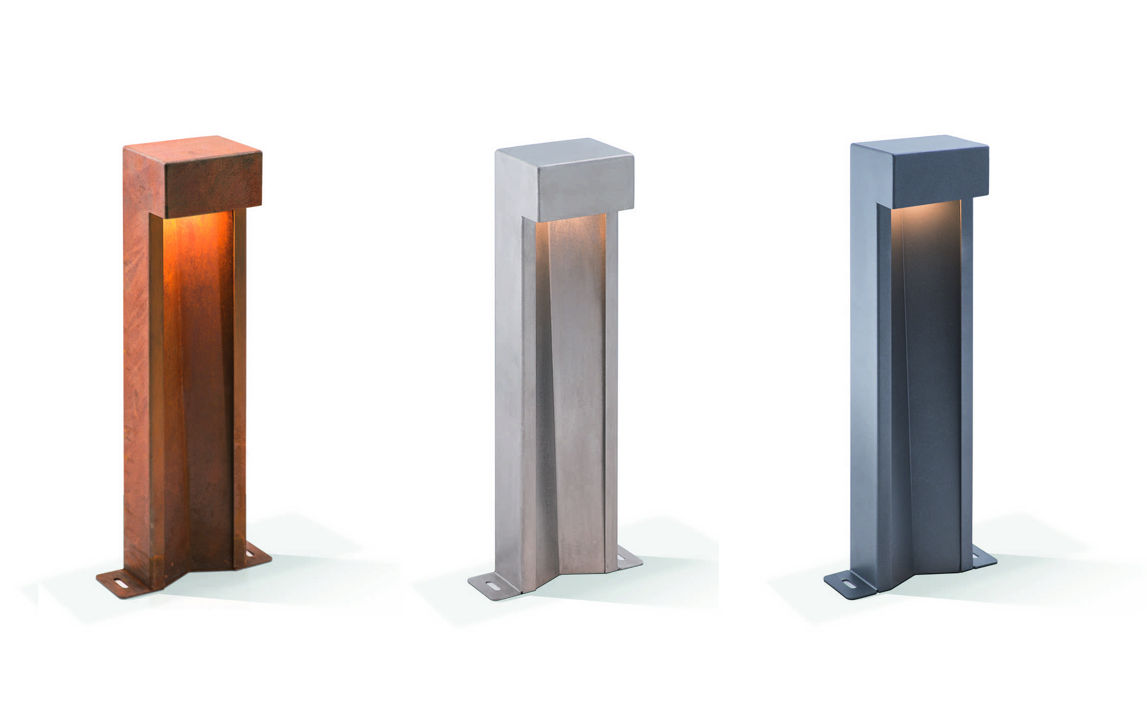 Drei rechteckige Außenleuchten in Rost-, Silber- und Grauoptik leuchten sanft nach unten, alle auf weißen Flächen stehend, geeignet für Garten- oder Wegbeleuchtung.