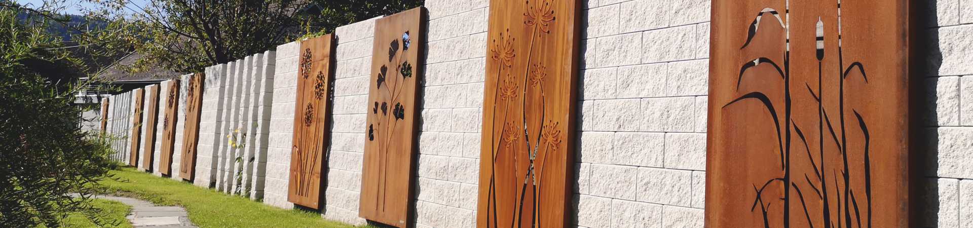 Sichtschutz VISTA mit verschiedenen Motiven in Natursteinmauer integriert